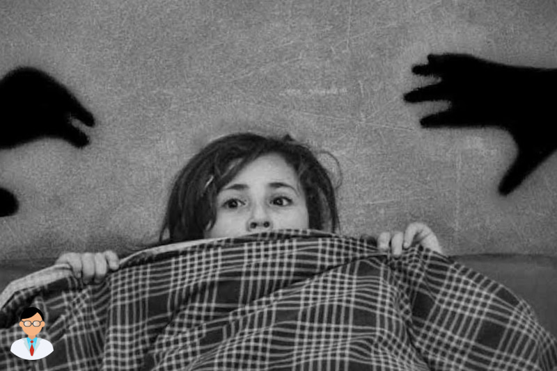 Человек лежит в кровати и испытывает страх